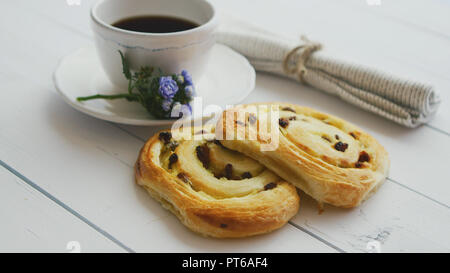 Deliziosi dolci con uvetta e una tazza di caffè vista dall'alto. Foto Stock