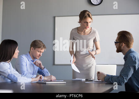 Arrabbiato ceo femmina scolding poco professionale dei dipendenti per un lavoro fatto male Foto Stock