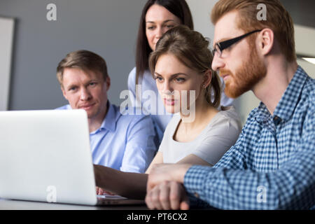 Grave del team leader per spiegare i dati online sul laptop per colleagu Foto Stock