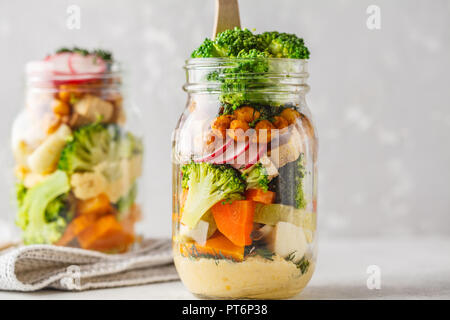 In casa sani Mason Jar con insalata di verdure al forno, hummus, tofu e ceci. Cibo sano, disintossicazione, pulire mangiare o vegano concetto. Foto Stock