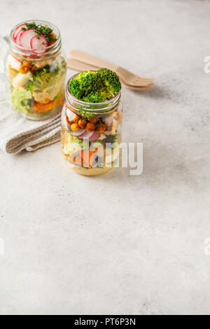 In casa sani Mason Jar con insalata di verdure al forno, hummus, tofu e ceci. Cibo sano, disintossicazione, pulire mangiare o vegano concetto. Foto Stock