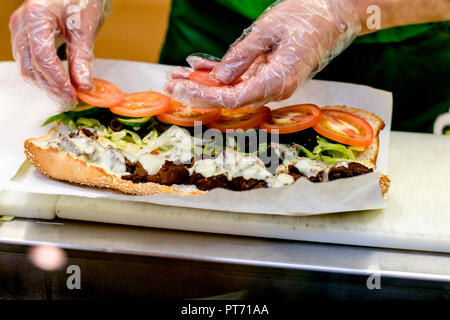 Il venditore al fast food bar prepara un sandwich Foto Stock