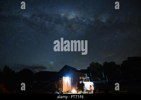 Camping sotto la Via Lattea stelle Eaglehawk collo tasmania con tenda e la trazione a quattro ruote motrici (4RM) e camp comunale edificio in background Foto Stock