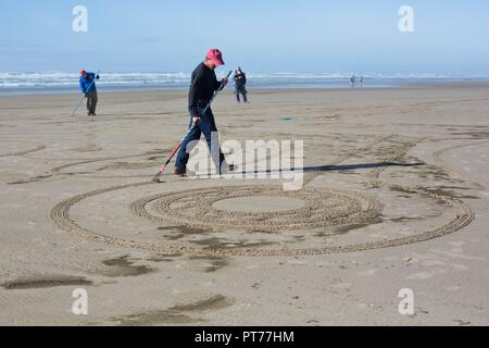 Un volontario che lavora su un grande labirinto di sabbia creato da Denny Dyke, a Heceta Beach in Firenze, Oregon, Stati Uniti d'America. Foto Stock