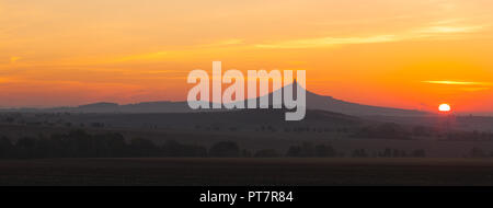 La silhouette di Hazmburk castello presso sunrise.Central Bohemian Uplands,Repubblica Ceca. Nella parte superiore della montagna vi è la rovina di un cast medievale Foto Stock