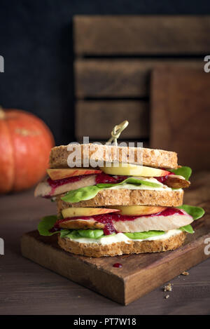 La Turchia o pollo avanzi di sandwich con ripieno e salsa di mirtilli. Appena sfornati dal giorno del Ringraziamento o tacchino di Natale gli avanzi sul crusty wholemea Foto Stock