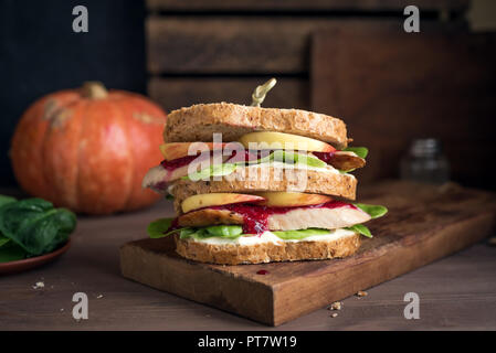 La Turchia o pollo avanzi di sandwich con ripieno e salsa di mirtilli. Appena sfornati dal giorno del Ringraziamento o tacchino di Natale gli avanzi sul crusty wholemea Foto Stock