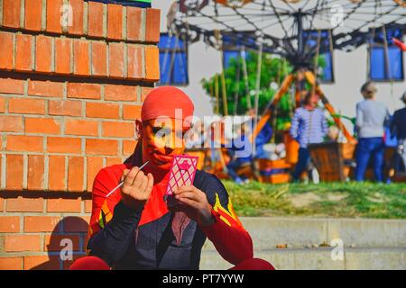 HUSTOPECE, Repubblica Ceca - 7 ottobre 2018: Street performer mettendo sul suo viso make-up. Artisti di strada può ingannare i passanti e intrattenere tourist Foto Stock
