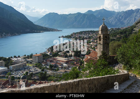 Vista in elevazione della storica medioevale della città murata di Kotor in Montenegro guardando giù sentiero di montagna per la Chiesa di Nostra Signora del Rimedio torre campanaria. Foto Stock