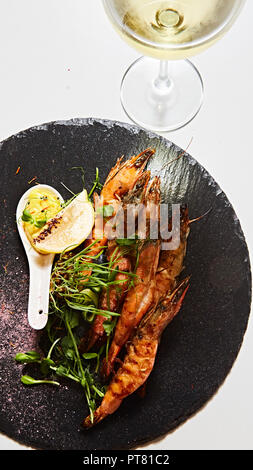 Grigliata di gamberi spiedini. Frutti di mare, shelfish. Gamberi spiedini con erbe aromatiche, aglio e limone. Foto Stock