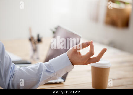 L'uomo la meditazione seduta al posto di lavoro e le mani vicino fino Foto Stock