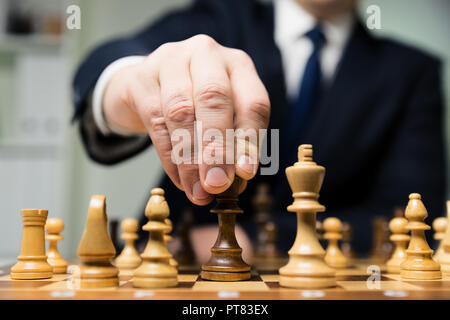 Mano di imprenditore di scacchi in movimento figura in concorrenza successo giocare. strategia, gestione o il concetto di leadership Foto Stock