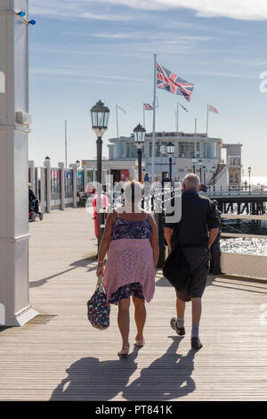 Worthing Sussex, Regno Unito; il 7 ottobre 2018; un paio di distanza a piedi dalla telecamera su Worthing Pier. Una Unione Jack vola da un pennone Foto Stock