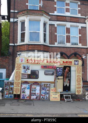 Gypsy palmist Rosa Lee guarda fuori dalla sua roulotte parcheggiate nel cortile anteriore della casa sulla Noel Street, Nottingham Forest opposta Rec durante la fiera d'oca Foto Stock