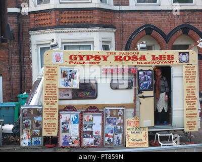 Gypsy palmist Rosa Lee guarda fuori dalla sua roulotte parcheggiate nel cortile anteriore della casa sulla Noel Street, Nottingham Forest opposta Rec durante la fiera d'oca Foto Stock