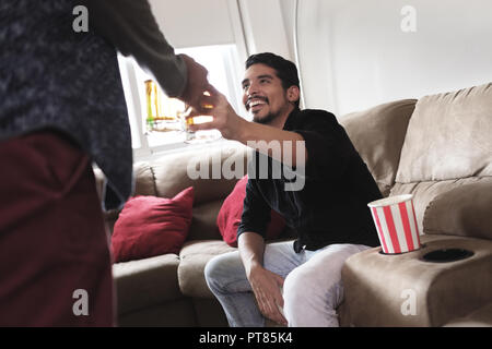 Coppia omosessuale, gay-persone. Felice partner maschi e gli amici la visione di gioco di sport sulla TV di casa e ridere. Foto Stock