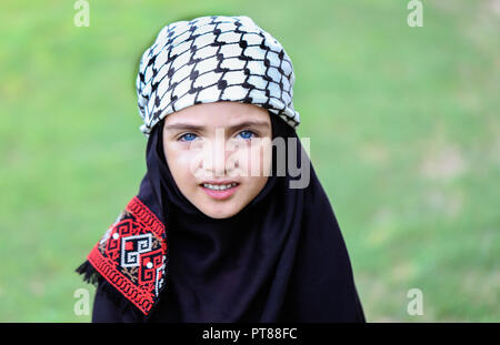 Una foto di una ragazza palestinese con un tradizionale araba Keffiyeh sciarpa sul suo capo. Foto Stock