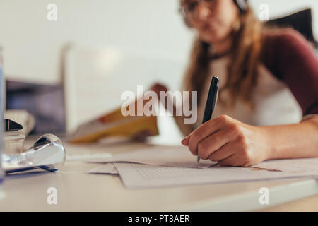 Le mani della donna programmatore codici di scrittura sulla carta mentre lo sviluppo di nuovo software in ufficio. Donna note di scrittura sulla carta mentre si lavora al tech startup. Foto Stock