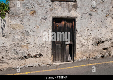 Vecchia porta di legno sulla costruzione di facciata in rovina , casa abbandonata Foto Stock