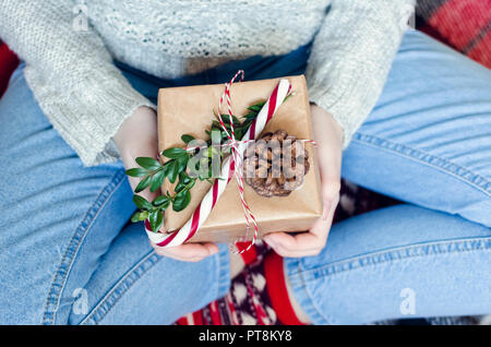 Womans mani tenere il Natale o il nuovo anno decorato confezione regalo. Buon Natale concetto. Stagionale della scheda Messaggi di saluto. Buone vacanze. Vista da sopra. Foto Stock