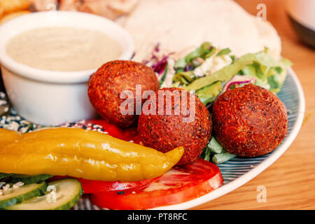 Vista ravvicinata del falafel pita, verdure e hummus su piastra tradizionale arabo israeliano o snack Foto Stock