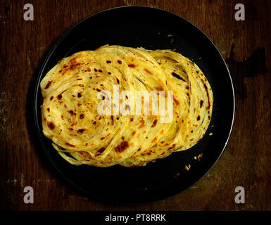 Il Kerala paratha / porotta / roti / parotta barotta // naan layered flatbread realizzato da maida farina mangiare con Spicy Red Asian pollo al curry o arrosto Foto Stock