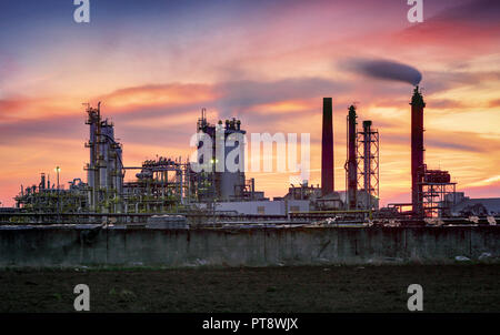 Raffineria di petrolio a drammatico crepuscolo Foto Stock