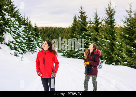 Felice ragazze su una escursione sulla neve sentiero di montagna Foto Stock