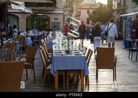 ALCUDIA, Maiorca, SPAGNA - Ottobre 2nd, 2018: Ristoranti i tavoli sono allestiti per un pasto serale nel centro storico di Alcudia Foto Stock