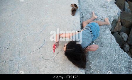 Teen posa sulla terra prendendo selfie Foto Stock