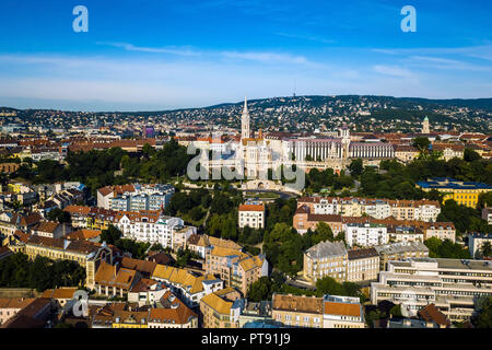 Budapest, Ungheria - Vista aerea della chiesa di Mattia (Matyas templom) e il famoso Bastione del Pescatore (Halaszbastya) al mattino con le colline di Buda un Foto Stock