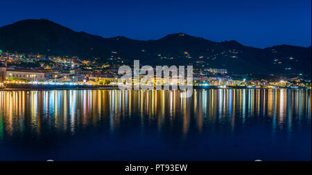 Lungomare di Cefalù in serata con luci che riflettono sull'acqua. La Sicilia Il sud dell'Italia. Foto Stock