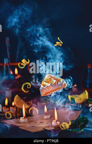 Evocazione di un pezzo di torta al limone con alchemica pentagram e candele. Magica ancora in vita con strega workplace su sfondo scuro con spazio di copia Foto Stock