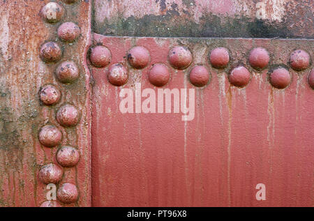 Gli sfondi e texture: vecchio metallo verniciato la superficie di parete con chiodatura, industriale abstract Foto Stock