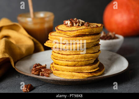 Frittelle di zucca con noci pecan e salsa al caramello su una piastra. Un sano gustoso autunno comfort food Foto Stock