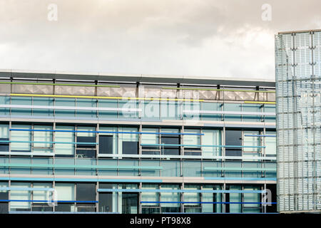 L'esterno di un ufficio moderno edificio con finestre in vetro blu. Foto Stock