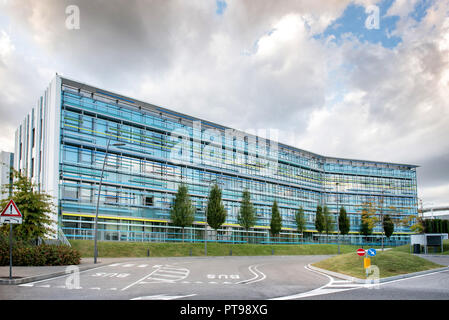 La strada di ingresso al grande ufficio moderno edificio con cloudscape sfondo. Foto Stock
