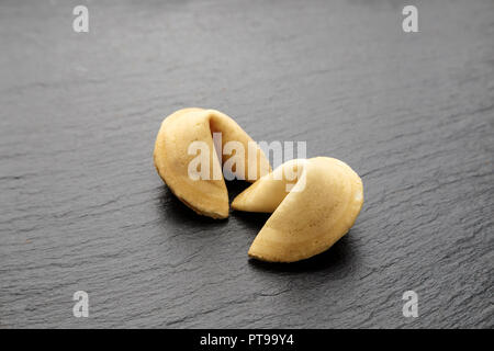 I cookie di cinesi con le previsioni su un nero ardesia sfondo vista superiore Foto Stock