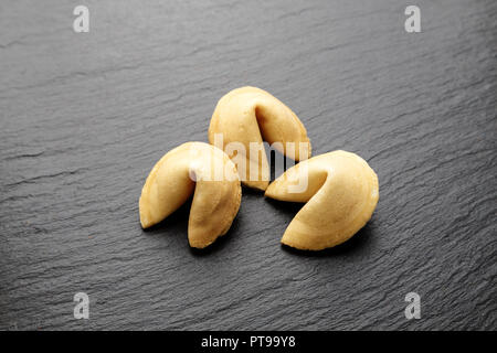 I cookie di cinesi con le previsioni su un nero ardesia sfondo vista superiore Foto Stock