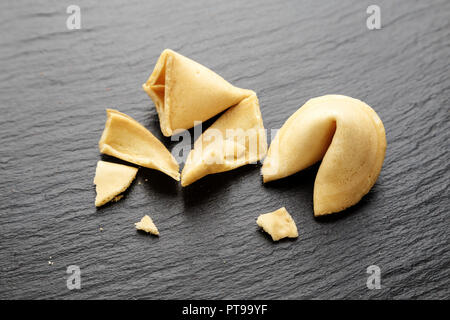 I cookie di cinesi con le previsioni su un nero ardesia sfondo vista superiore Foto Stock