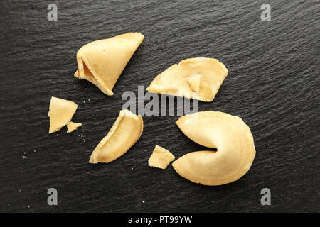 I cookie di cinesi con le previsioni su un nero ardesia sfondo vista superiore Foto Stock