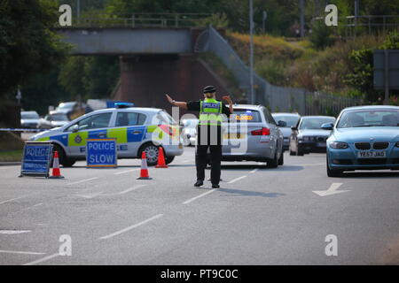 Un funzionario di polizia dirige il traffico sulla corsia Stranglands dovuta a un incendio a Ferrybridge Power Station Foto Stock