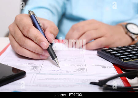 Immagine della clipboard, forma, bicchieri, calcolatrice, penna e telefono. L uomo è tenendo la penna in mano Foto Stock