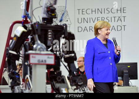 Darmstadt, Hessen, Germania. 08 ott 2018. Il cancelliere Angela Merkel (CDU) sorge accanto al robot umanoide Johnny durante una visita alla Technical University. Durante una dimostrazione, operazioni di ricerca e salvataggio robot da "Hector' team sono utilizzati, che possono, ad esempio, cercare autonomamente per persone sepolte. Credito: Uwe Anspach/dpa/Alamy Live News Foto Stock