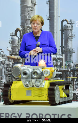 Darmstadt, Hessen, Germania. 08 ott 2018. Il Cancelliere federale Angela Merkel (CDU) sta dietro un robot del "Energia Robotics' progetto durante una visita alla Technical University. Durante una dimostrazione, operazioni di ricerca e salvataggio robot da "Hector' team sono utilizzati, che possono, ad esempio, cercare autonomamente per persone sepolte. Credito: Uwe Anspach/dpa/Alamy Live News Foto Stock