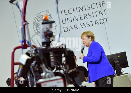 Darmstadt, Hessen, Germania. 08 ott 2018. Il cancelliere Angela Merkel (CDU) sorge accanto al robot umanoide Johnny durante una visita alla Technical University. Durante una dimostrazione, operazioni di ricerca e salvataggio robot da "Hector' team sono utilizzati, che possono, ad esempio, cercare autonomamente per persone sepolte. Credito: Uwe Anspach/dpa/Alamy Live News Foto Stock