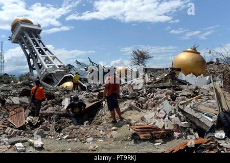 Palu. 8 Ott, 2018. La gente a piedi sui resti di una moschea danneggiati sul Balaroa a Palu, Sulawesi centrali, Indonesia. Numero di morti da più potenti i terremoti e un conseguente tsunami colpisce Sulawesi centrale provincia di Indonesia il 28 settembre è saltato a 1,948 il lunedì e più di 5.000 altri sono andati dispersi, secondo un disastro agenzia qui ufficiale. Credito: Agung Kuncahya B./Xinhua/Alamy Live News Foto Stock