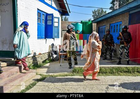 Gli elettori del Kashmir a piedi al di fuori di un vota in corrispondenza di una stazione di polling durante la prima fase delle elezioni locali in Srinagar, Indiano Kashmir amministrato. In mezzo a stretto accordi in materia di sicurezza, il voto ha iniziato per la prima fase della città di organismi locali (ULB) elezioni nel Jammu e Kashmir il 08 ottobre. Foto Stock