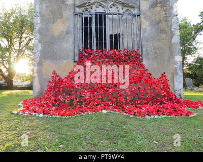 Murston, Kent, Regno Unito. 8 Ott, 2018. Regno Unito Meteo: il sole tramonta dietro Murston vecchia Chiesa che è stata decorata con migliaia di papaveri dal cuore Murston progetto papavero 2018 per commemorare il WW1 Centenario 2018. Cuore Murston Progetto e Swale in fiore sono state lavorando con la gente di Swale e hanno realizzato oltre 3000 papaveri uniche che ora rappresentano uno degli oltre 3000 eroi caduti provenienti da tutta la zona Swale che morì nella Prima Guerra Mondiale. Credito: James Bell/Alamy Live News Foto Stock