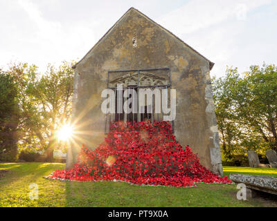 Murston, Kent, Regno Unito. 8 Ott, 2018. Regno Unito Meteo: il sole tramonta dietro Murston vecchia Chiesa che è stata decorata con migliaia di papaveri dal cuore Murston progetto papavero 2018 per commemorare il WW1 Centenario 2018. Cuore Murston Progetto e Swale in fiore sono state lavorando con la gente di Swale e hanno realizzato oltre 3000 papaveri uniche che ora rappresentano uno degli oltre 3000 eroi caduti provenienti da tutta la zona Swale che morì nella Prima Guerra Mondiale. Credito: James Bell/Alamy Live News Foto Stock